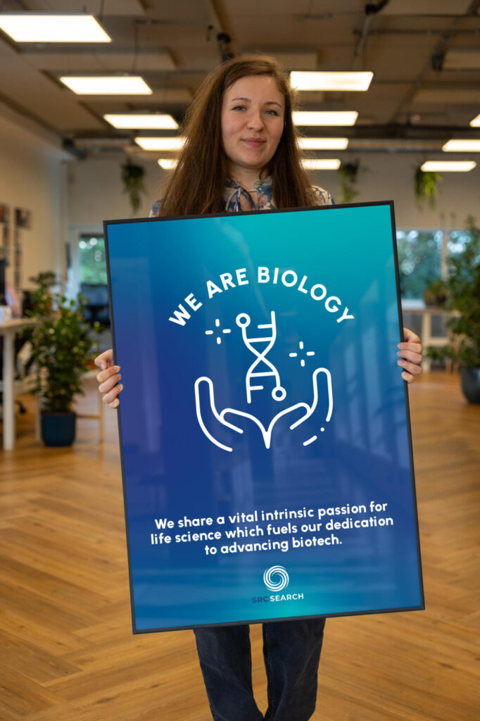 Person holding a BIOLOGY poster.